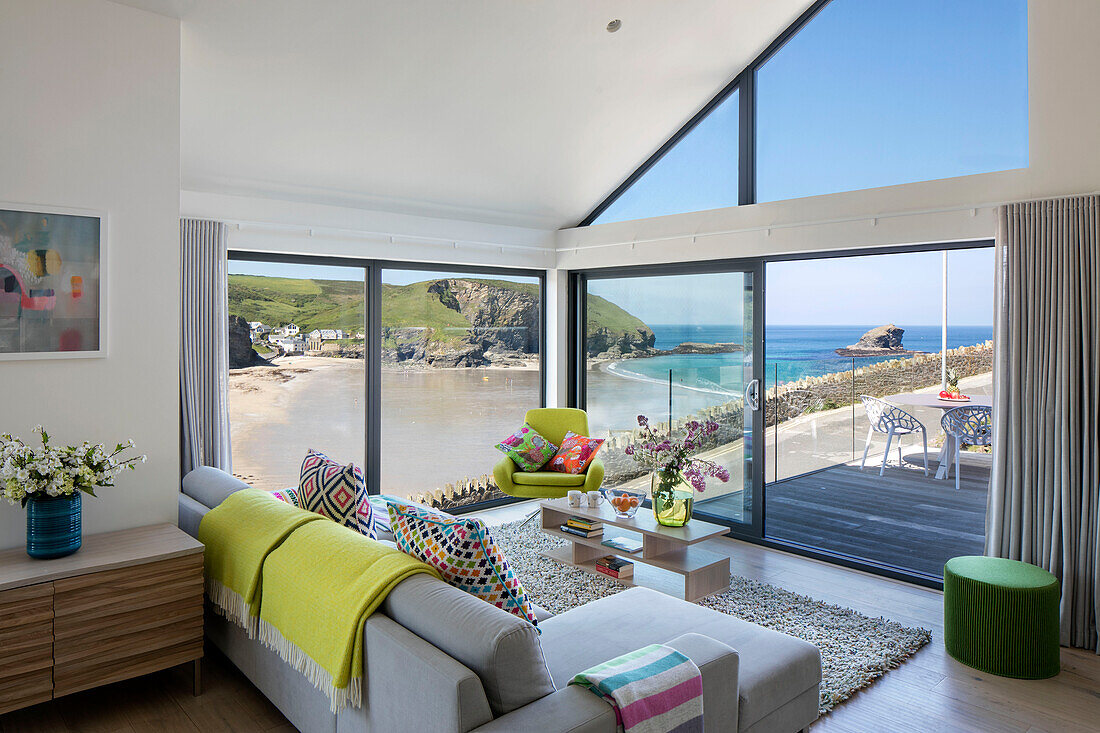 Wohnzimmer mit offener Tür zur Terrasse und Strandblick Cornwall UK