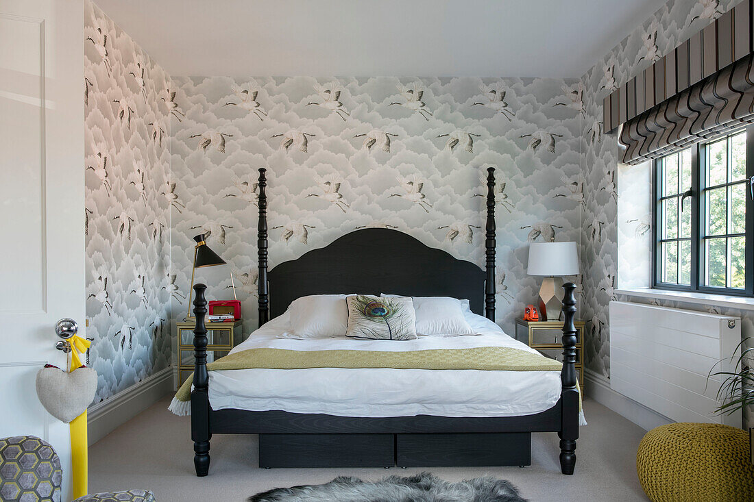 Schwarzes Doppelbett mit Storchmustertapete in einem modernisierten Haus im Arts-and-Crafts-Stil in London UK
