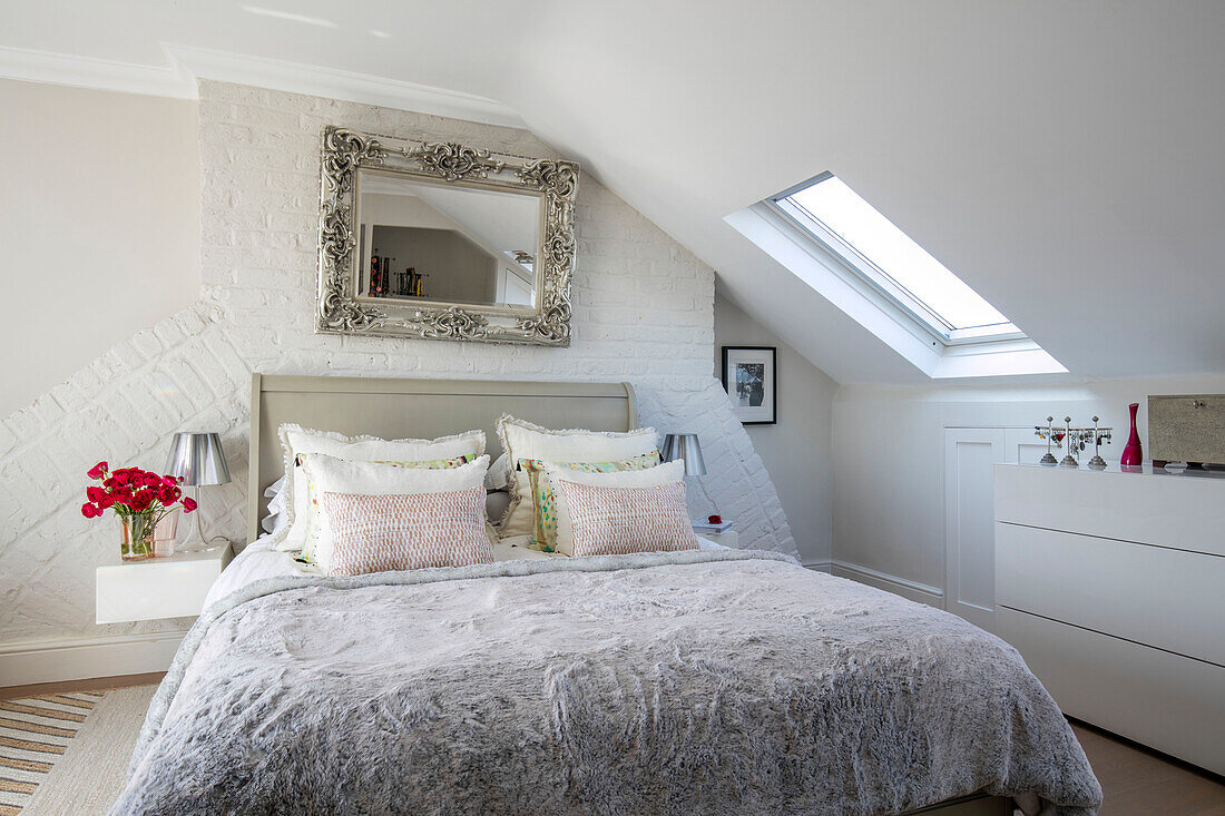 Decorative mirror above double bed in attic of North London UK
