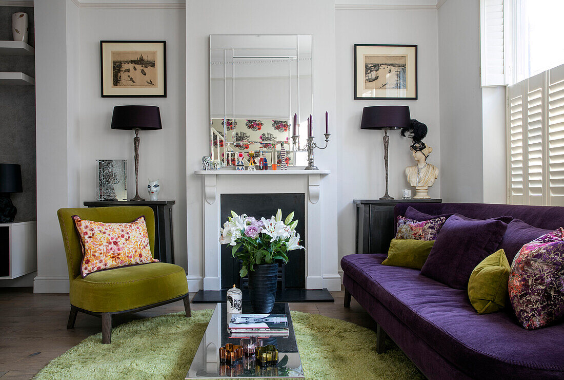 Limonengrüner und violetter Samt mit Lilien auf niedrigem Tisch in einem Haus in Nord-London (UK)