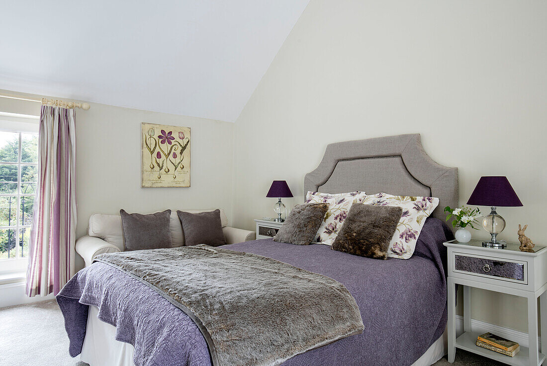 Graue Decke und Kissen mit lila Lampen im Schlafzimmer in Sussex UK