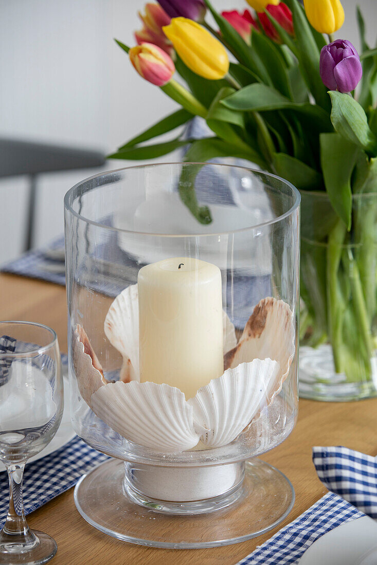 Kerzenständer aus Glas und Tulpen auf einem Tisch in einem unter Denkmalschutz stehenden Cottage in Cornwall UK