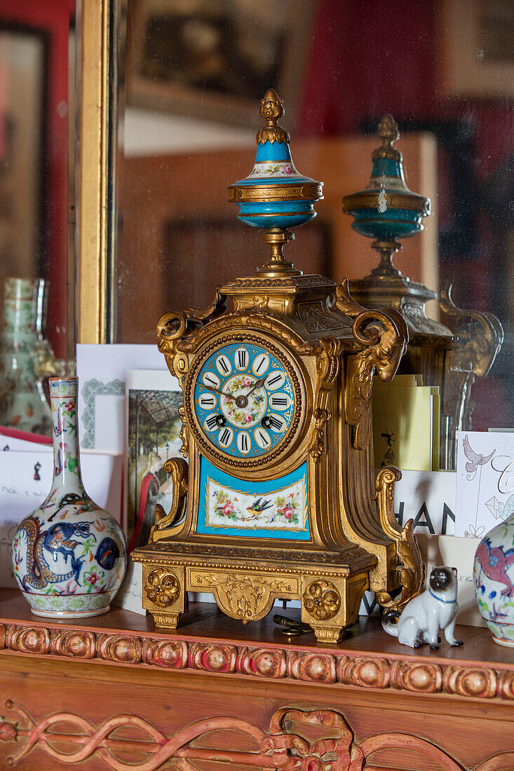 Antique clock with Chinese ornaments on mantlepiece in Sussex home