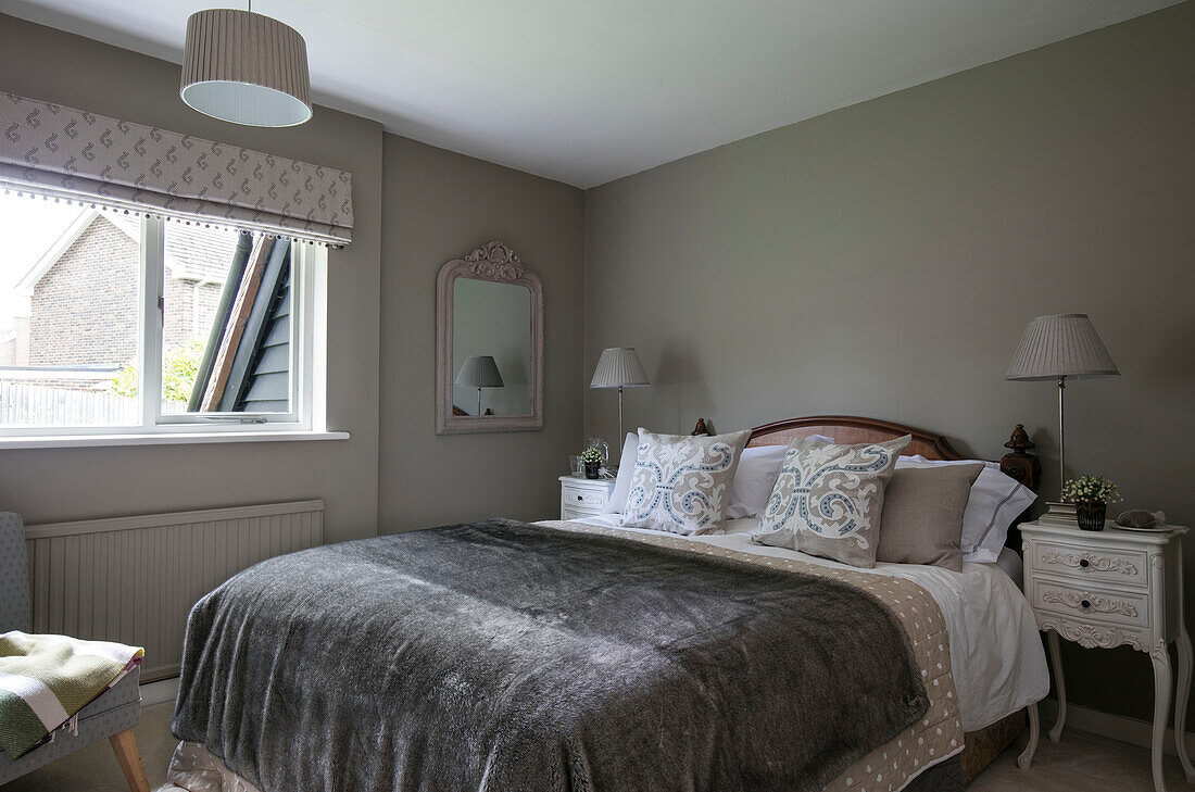 Graue Decke auf einem Doppelbett am Fenster in einem Haus in Kent UK