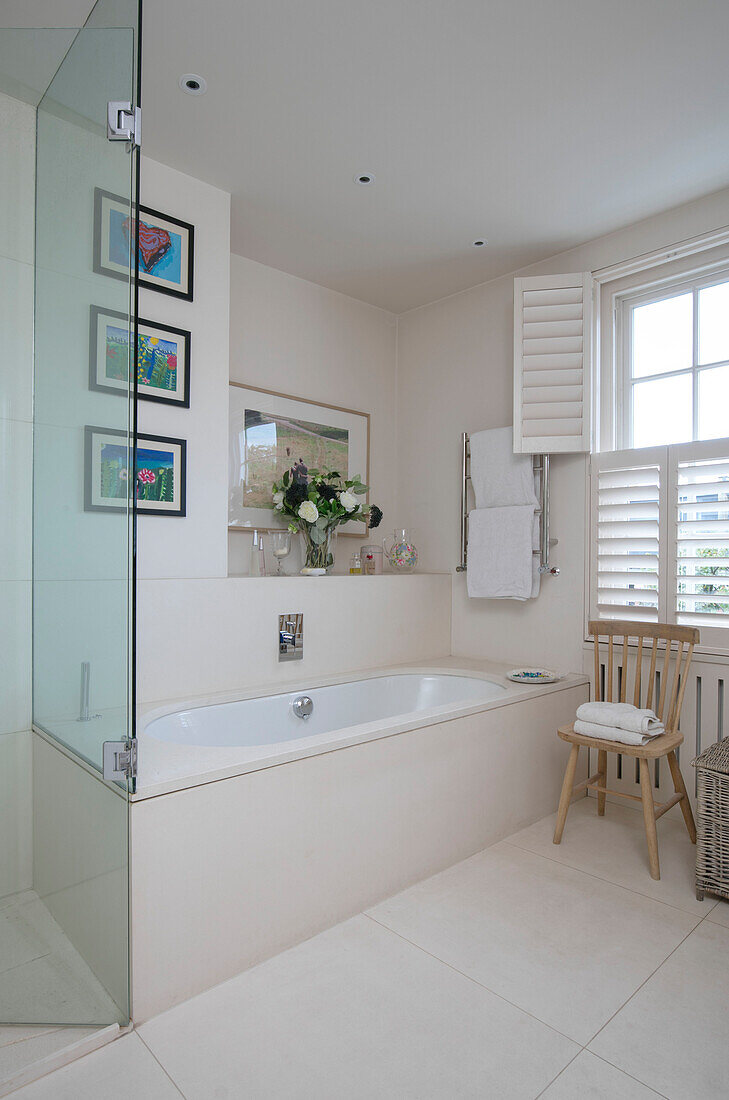 Glaswand und Badewanne mit Fensterläden in einem Londoner Haus UK