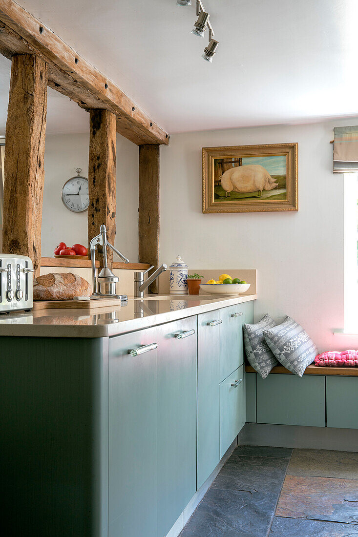 Grüne Einbauschränke mit Holzrahmen in einer Landhausküche in Kent UK