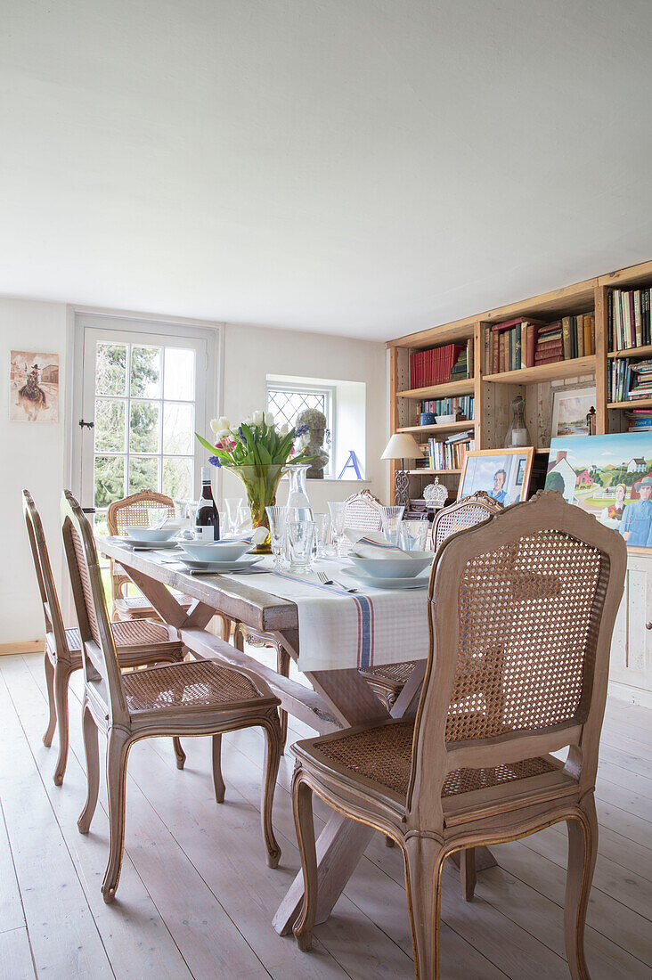 Regale aus alten Dielen mit Esszimmerstühlen aus Walnussholz am Tisch in einem Bauernhaus in Surrey, Großbritannien