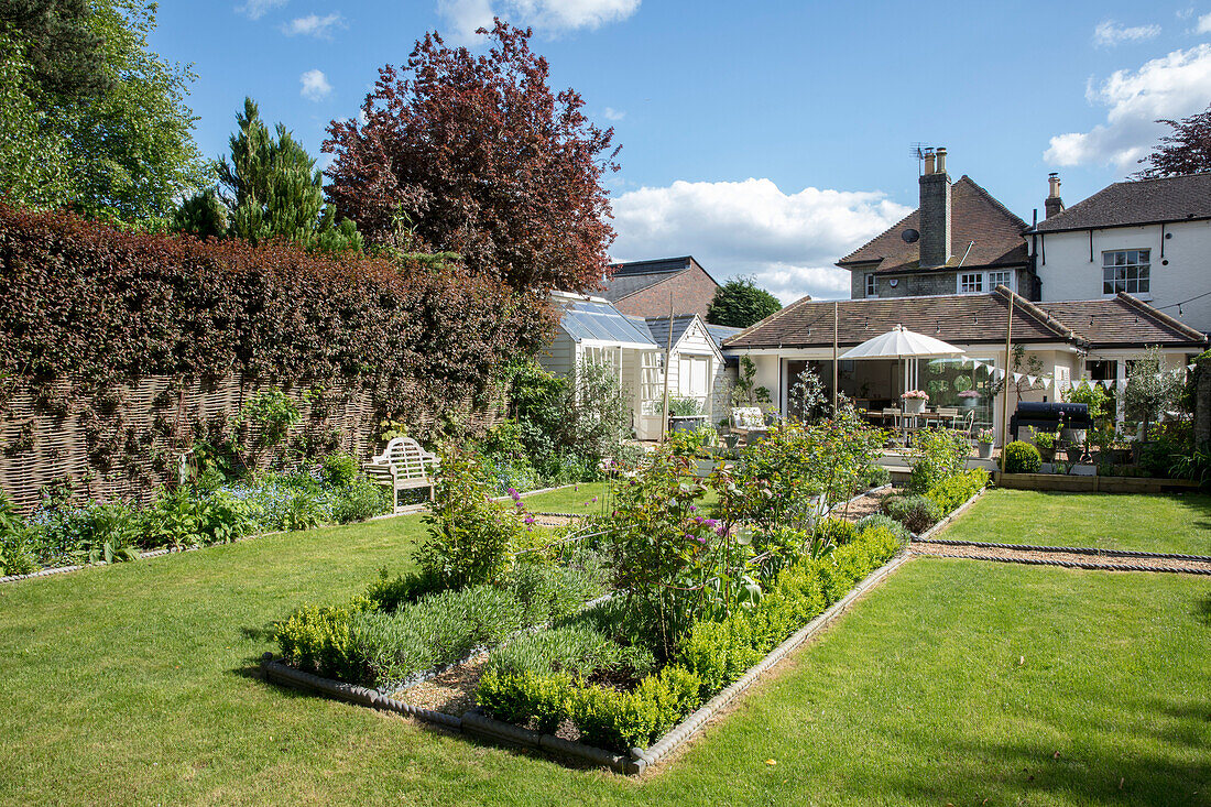 Blumenbeete und Wege mit Rasen im Garten eines unter Denkmalschutz stehenden Landhauses (Grade II) in Hertfordshire UK