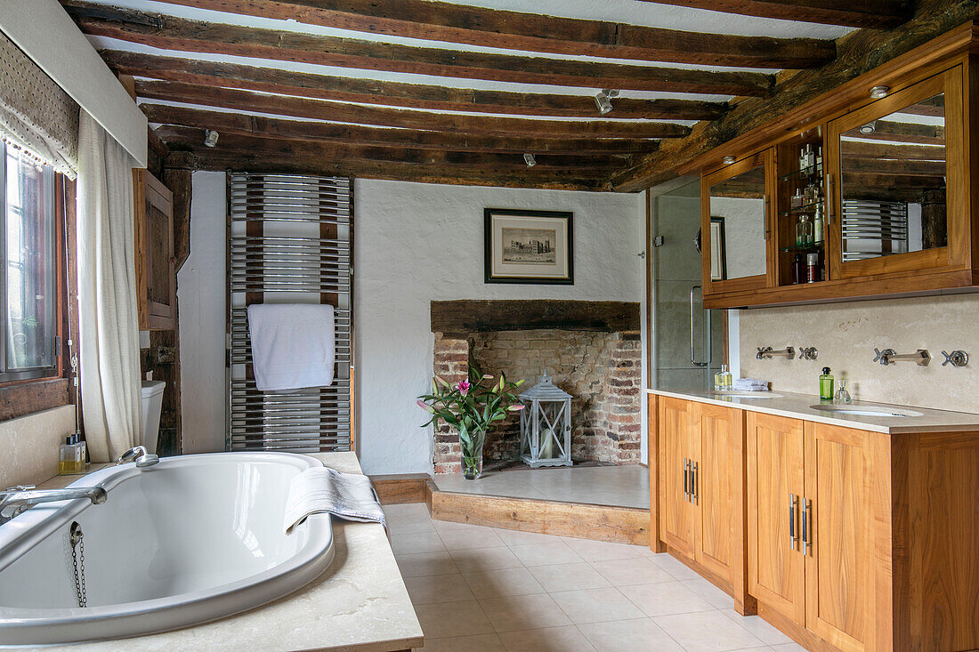 Verchromter Handtuchhalter und Spiegelschränke mit Badewanne im Fenster eines Bauernhauses in Kent, Großbritannien