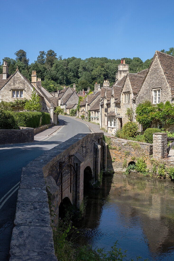 Straßenbrücke über einen Fluss mit Steinhäuschen in einem Dorf in Wiltshire UK