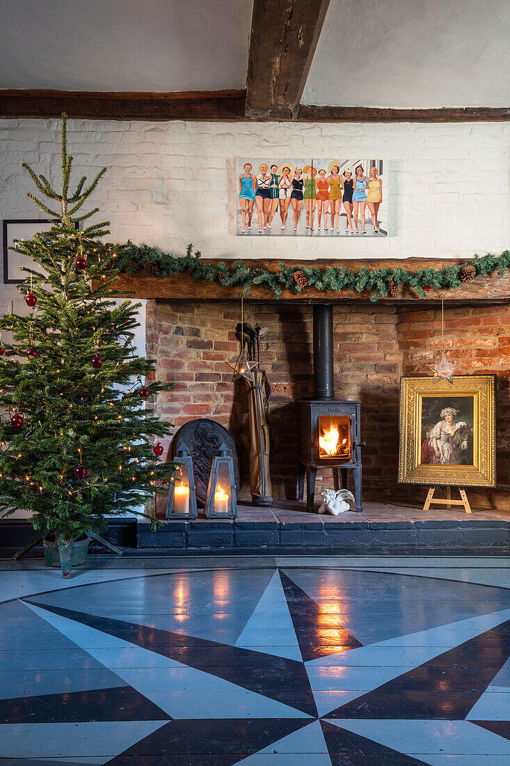 Weihnachtsbaum und Holzofen mit sternförmig bemalten Dielen Norfolk-Bauernhaus UK