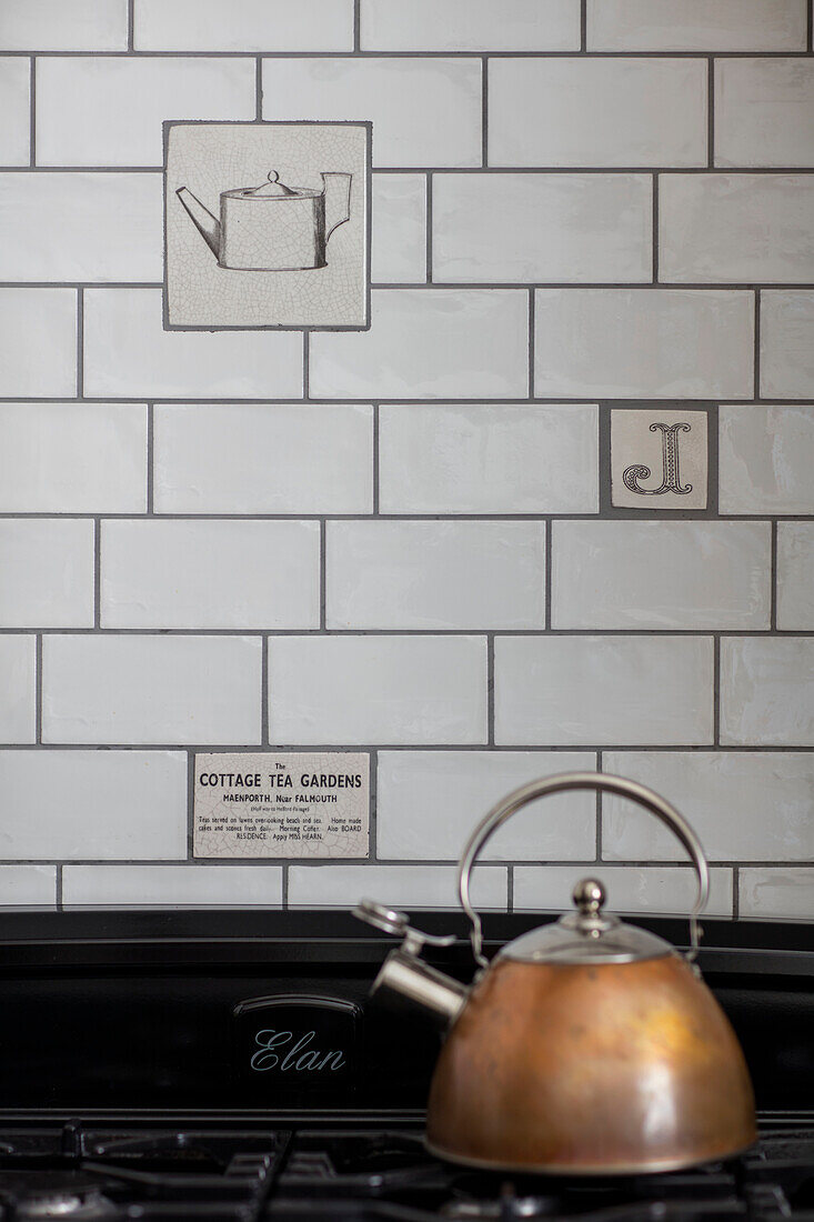 Feature and plain metro tiles with copper kettle on hob in Cumbrian kitchen UK