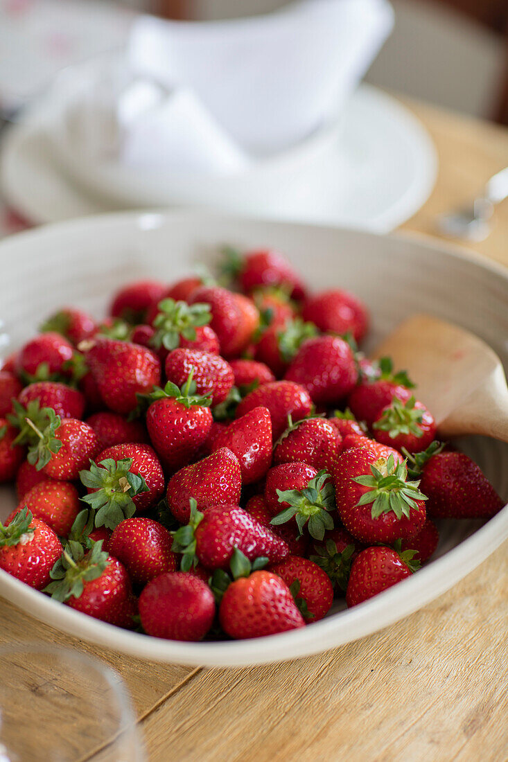 Bowl of fresh red srawberries in Georgian farmhouse Somerset, UK