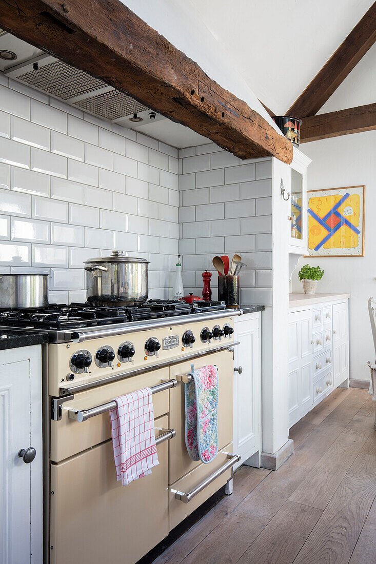 Range oven and white metro tiles with oak floorboards in Surrey cottage kitchen UK