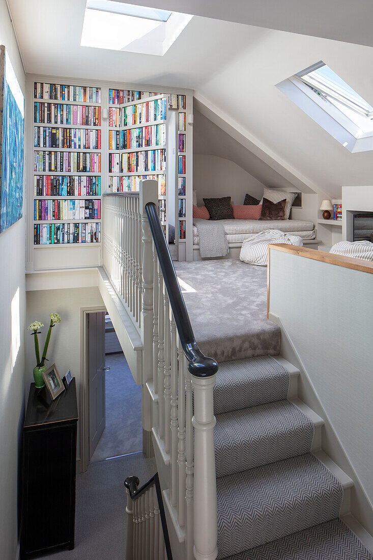 Open plan hidden loft space and snug with trompe l'oeil bookcase London UK