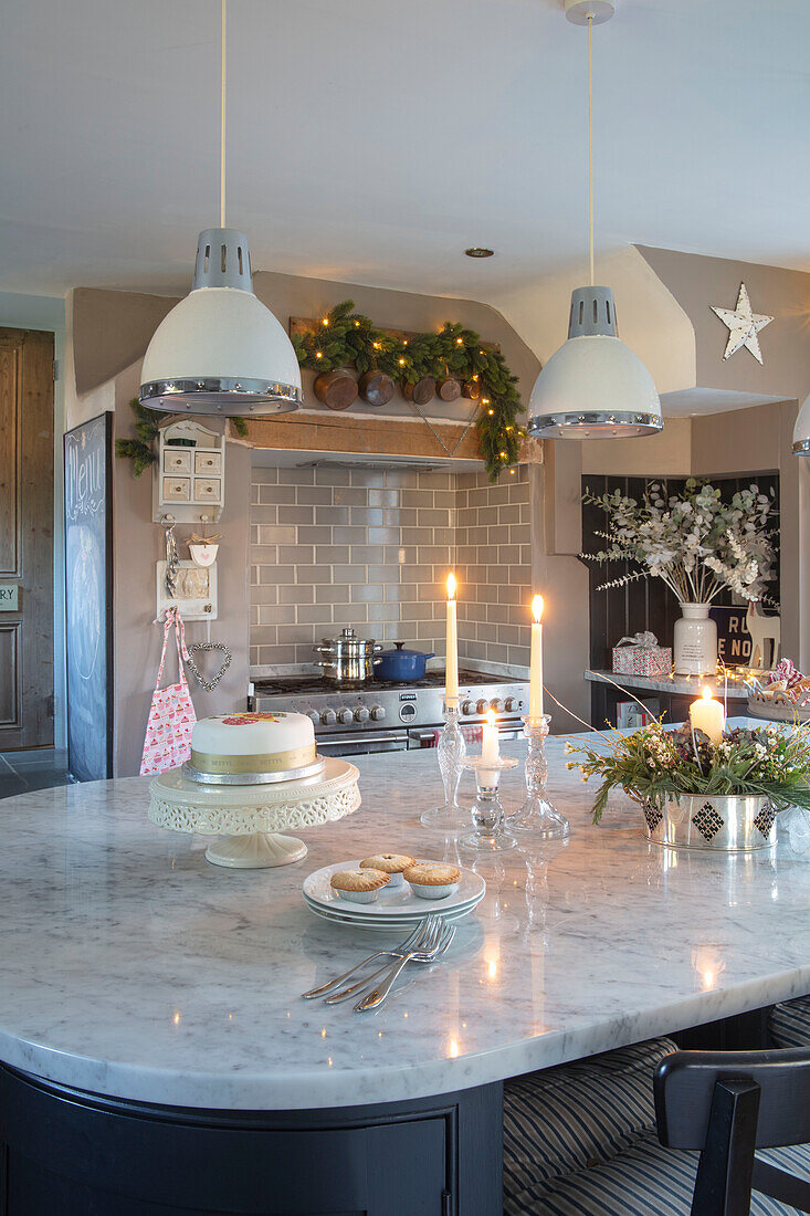 Kücheninsel mit weißen Hängeleuchten und Weihnachtskuchen in einem Landhaus in Berkshire UK