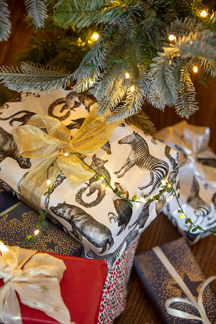 Presents wrapped in contemporary paper under tree in Hampshire UK