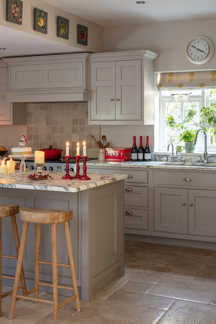 Burgoyne stone floor with Italian marble worktop and lit candles in Hampshire kitchen UK