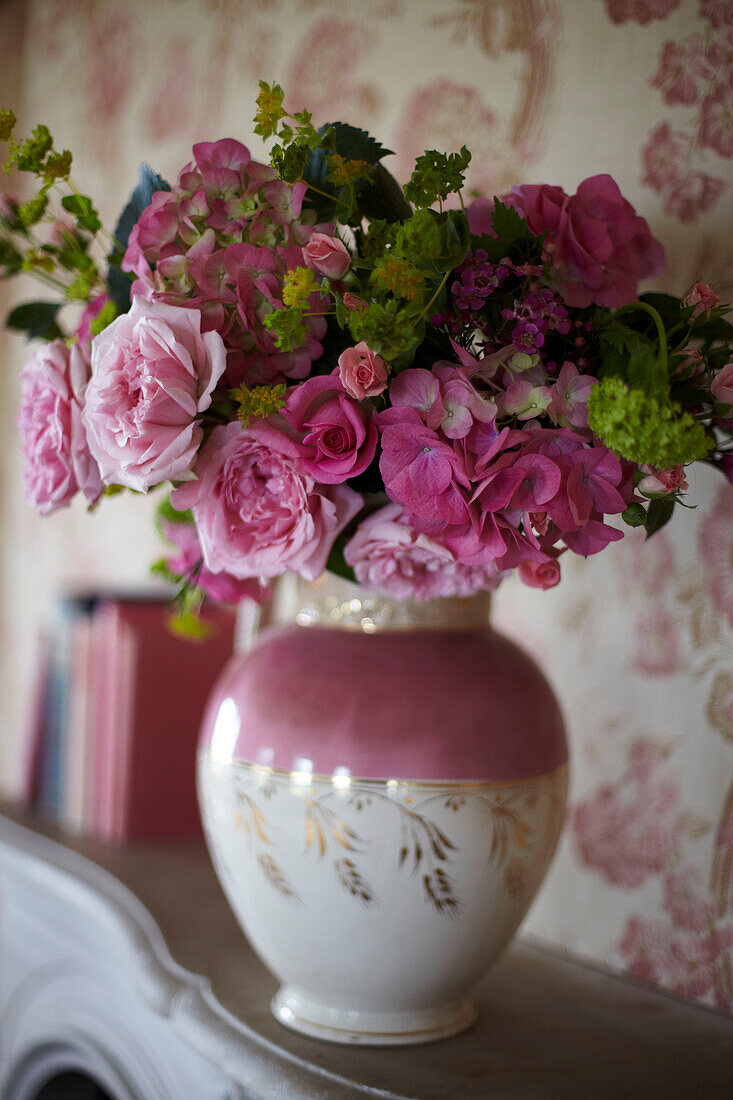 Vintage Blooms - Vase mit Schnittblumen in einem rosafarbenen Lüsterkrug auf einem Kaminsims