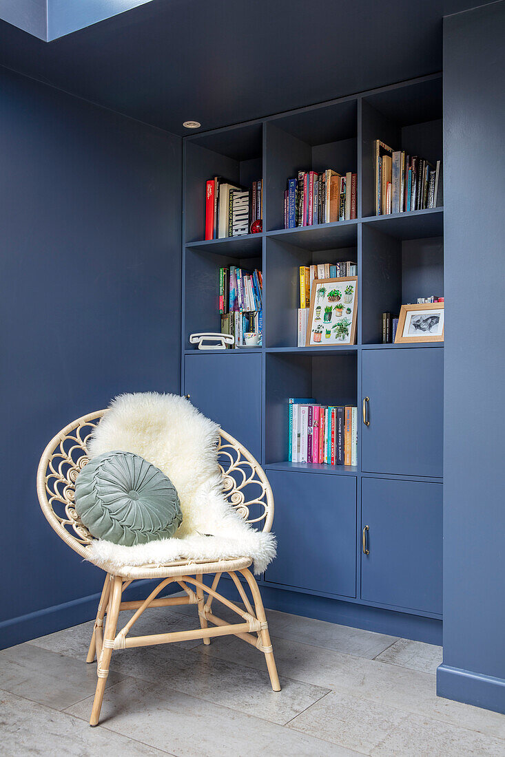 Wicker chair and blue storage unit with books Sussex UK