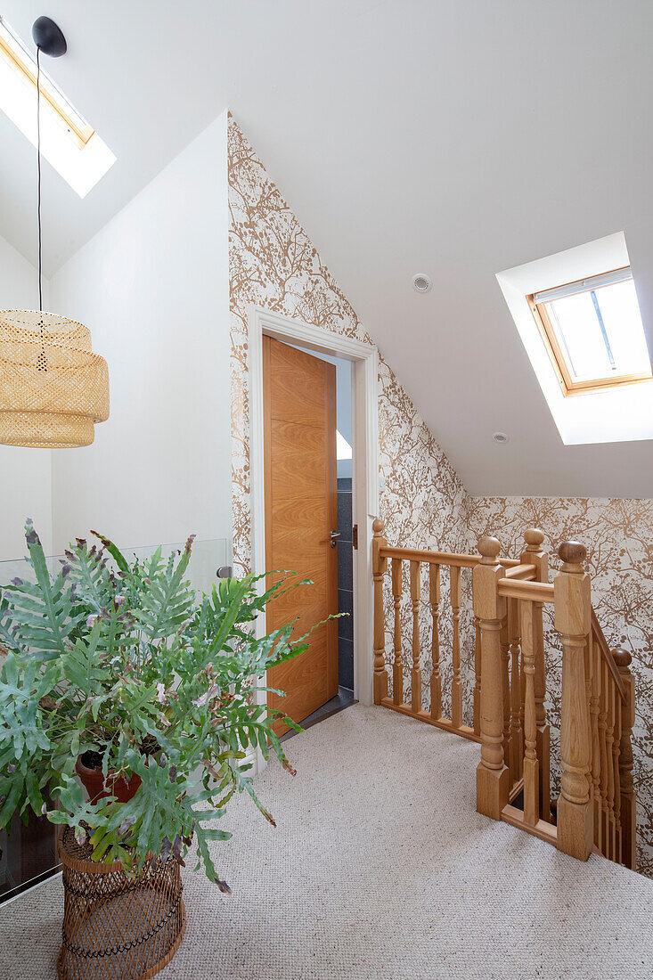 Goldgemusterte Tapete und Farn auf dem Treppenabsatz eines Hauses in Sussex UK