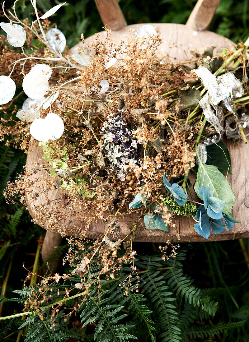 Getrocknete Blumen auf Holzstuhl in Farnen Isle of Wight hillside UK