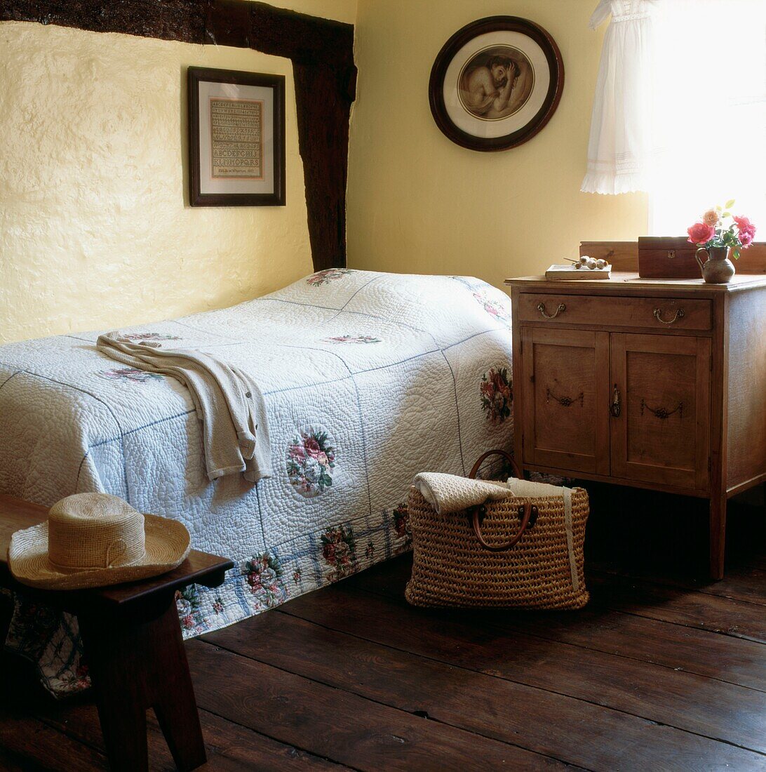 Gästezimmer mit amerikanischem Patchwork-Quilt und gestreiftem Eichenboden