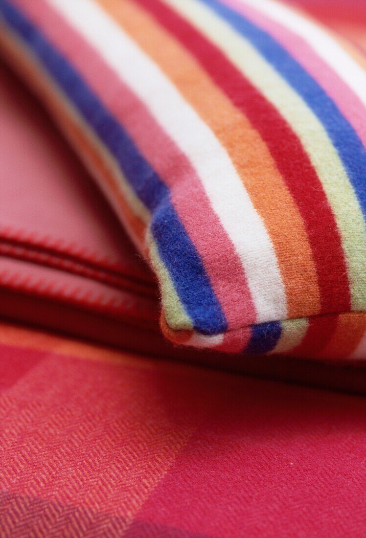 Colourful wool blanket and striped wool cushion detail