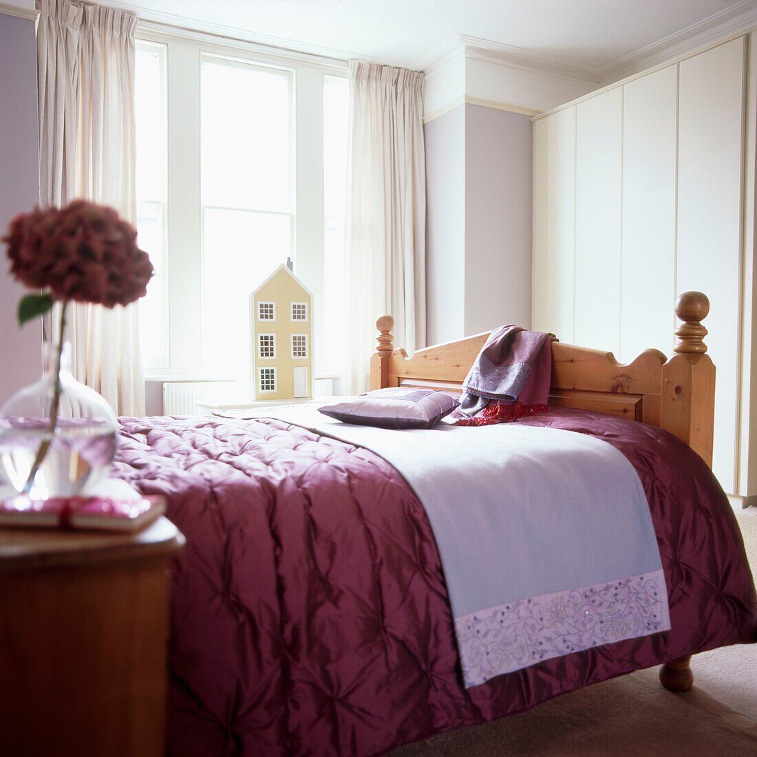 Master bedroom with purple satin quilt on double bed