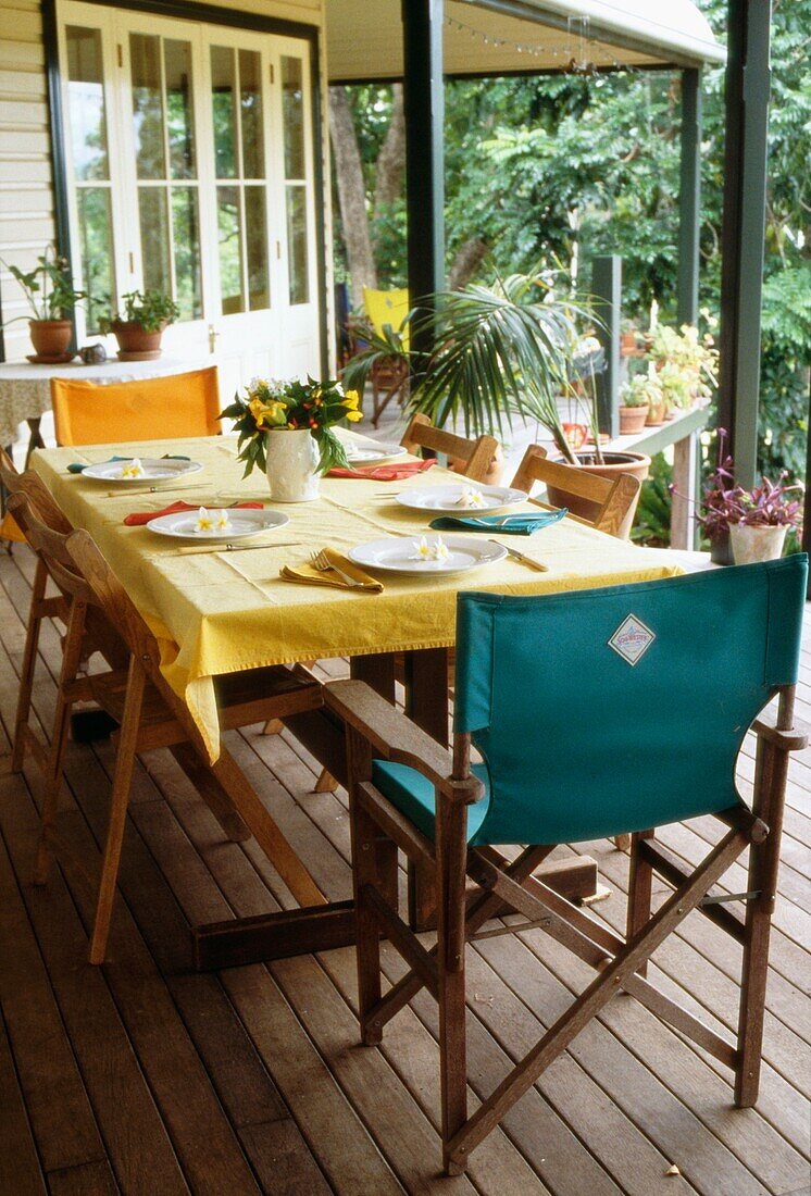 Dining table and fold up canvas garden chairs on a decked terrace