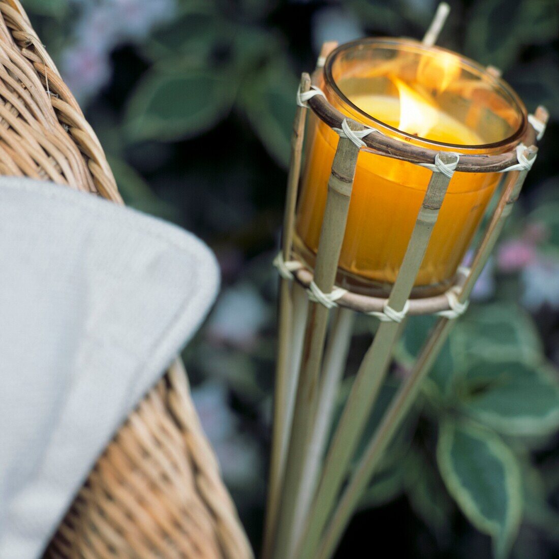 Bamboo torch with lighted candle in garden setting