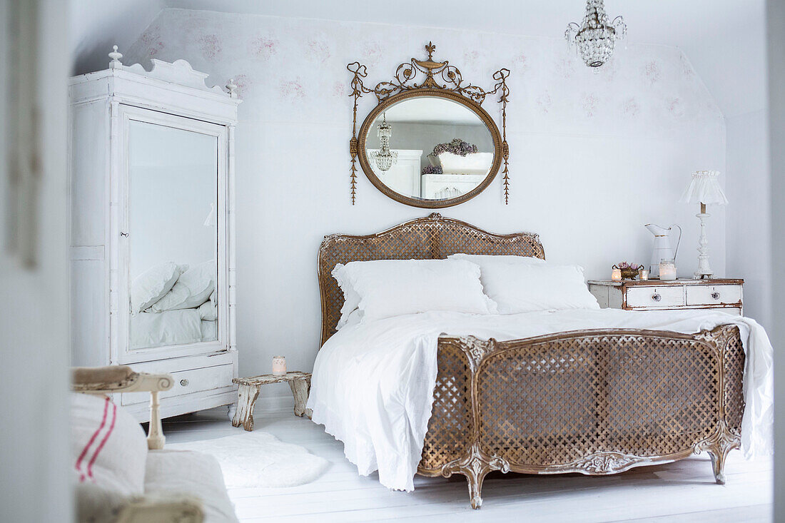 Scandinavian style bedroom with distressed paintwork and vintage bed and wardrobe