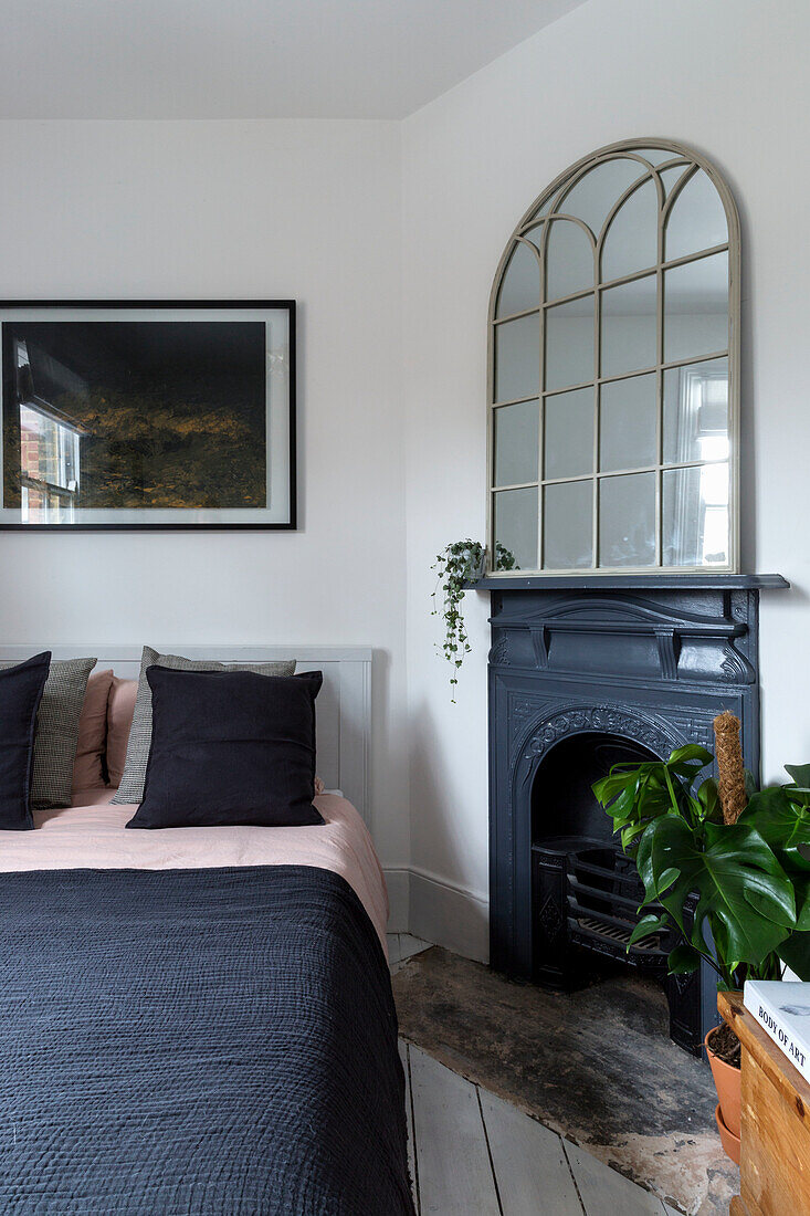 Bedroom with black fireplace and mirrored window