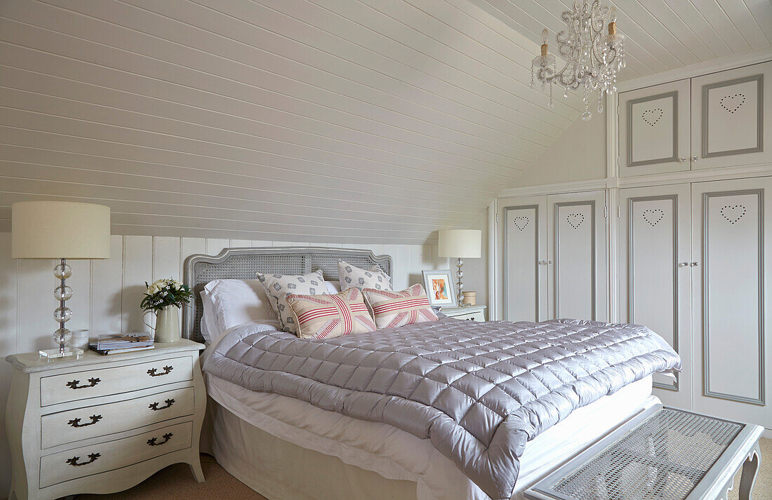 Großzügiges Schlafzimmer im Dachgeschoss mit Einbauschränken und heller Holzverkleidung