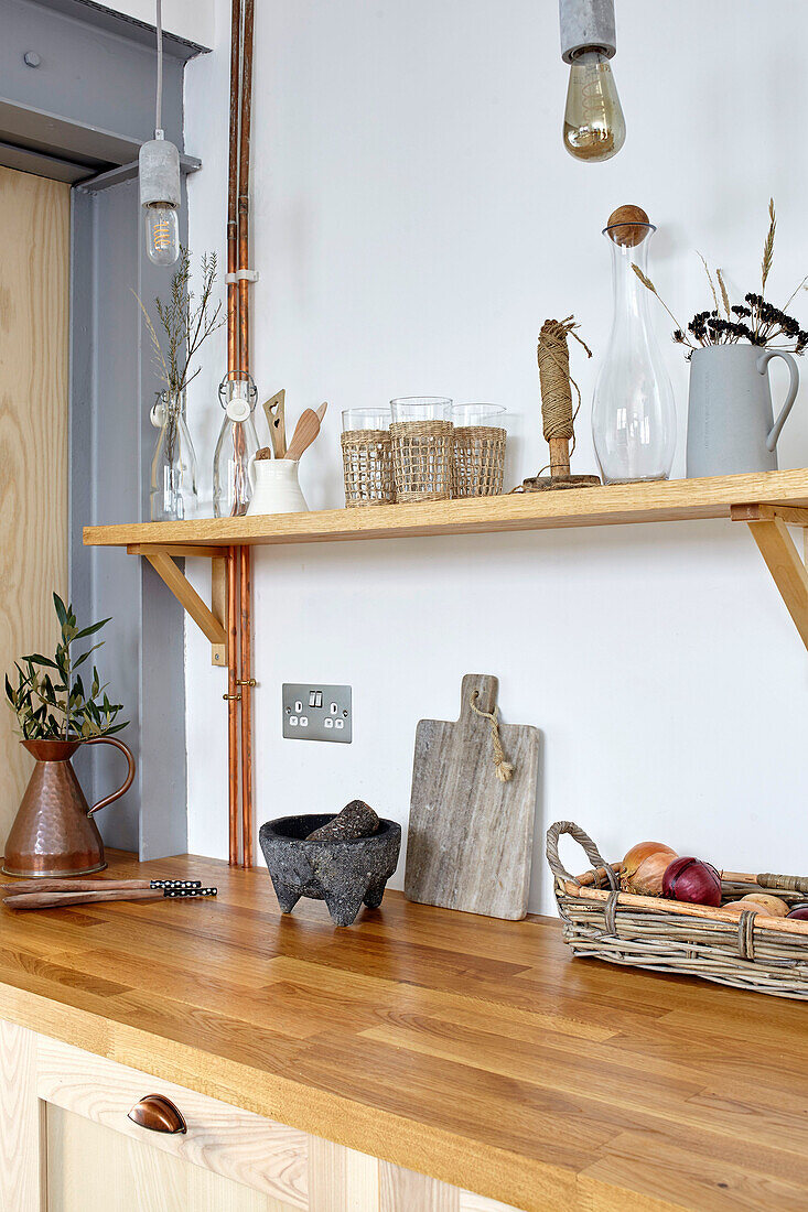 Einbauküche mit Holzarbeitsplatte, darüber Holzregal