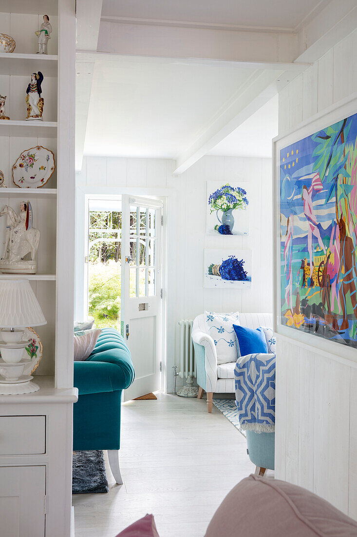 Bright living room with open passageway, blue and white furnishings and decoration