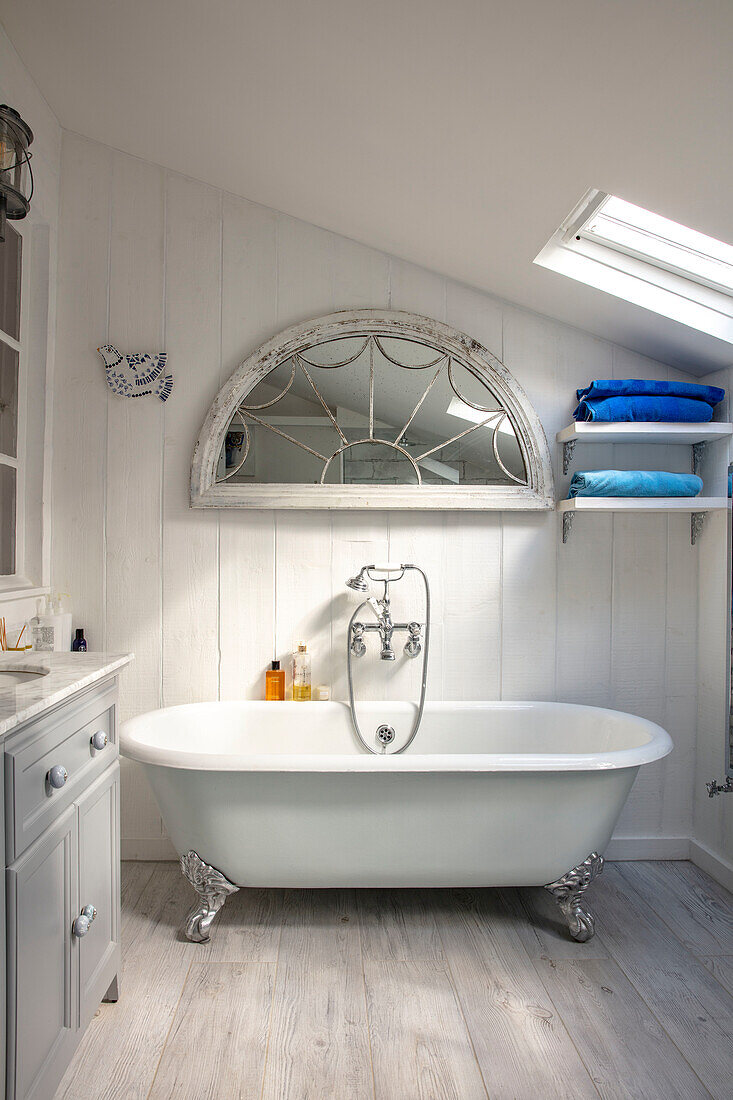 Freestanding bathtub with lion feet in bathroom in the attic