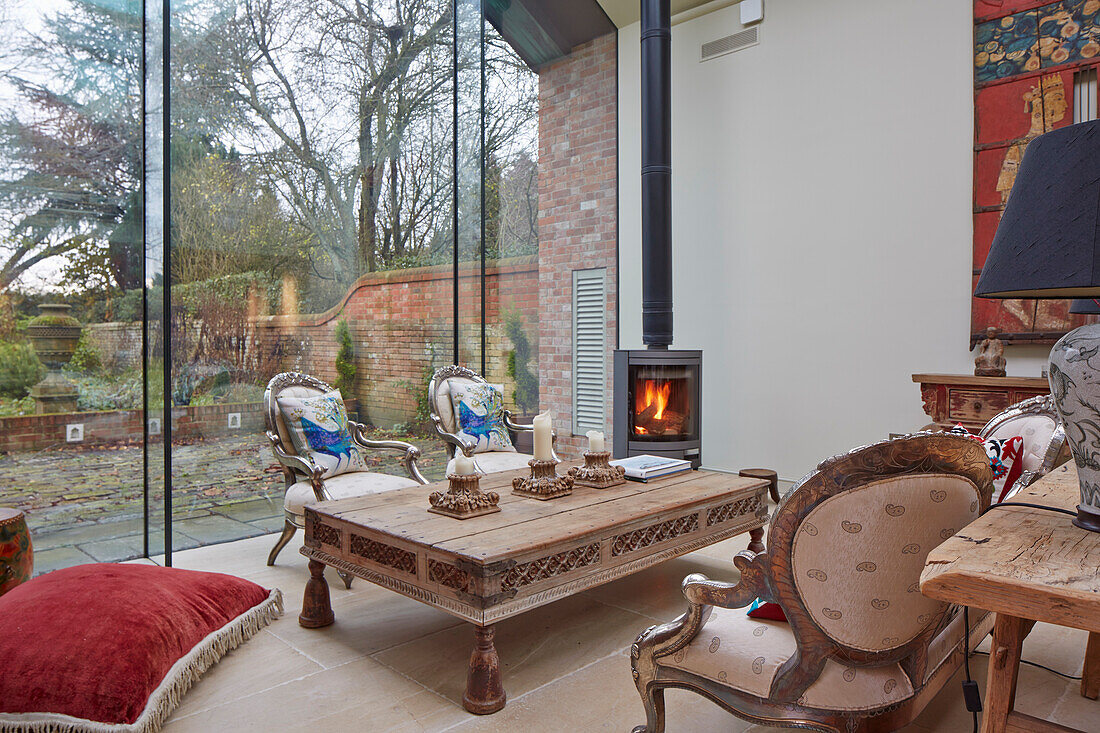 Wohnzimmer mit Kamin und Vintage-Möbeln, Blick in den Garten