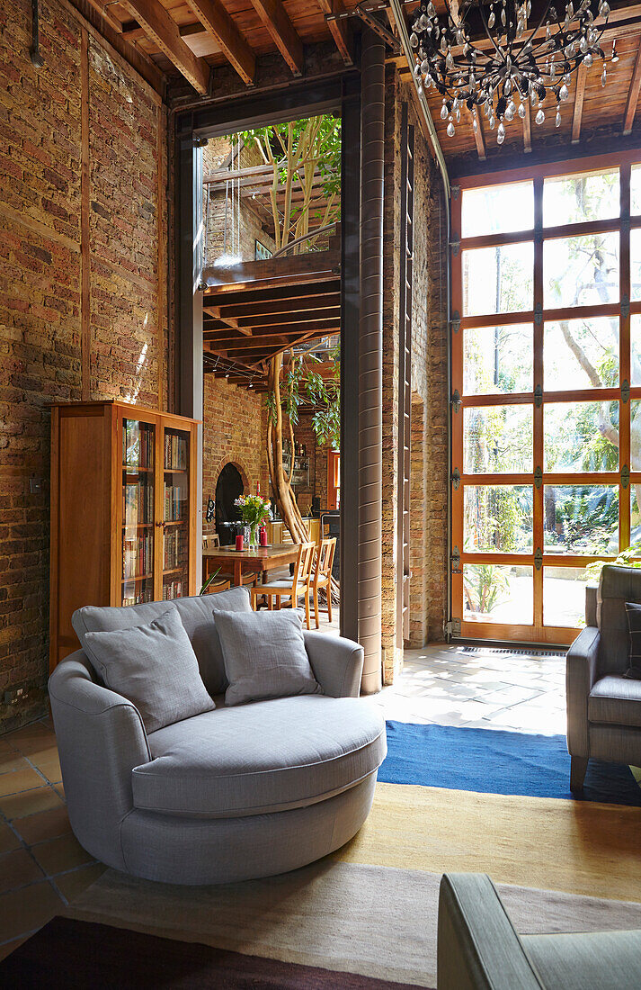 Seating area in high spacious room with brick walls