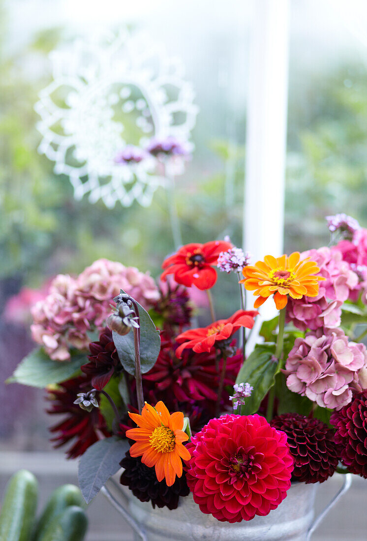 Bunter Blumenstrauß vor einem Fenster