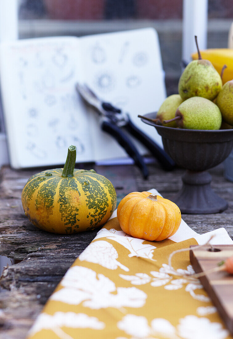 Autumnal table decoration with pumpkins and pears on a wooden table