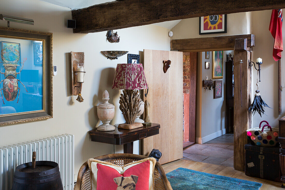 Urns and table lamp on antique sconce table in rustic room