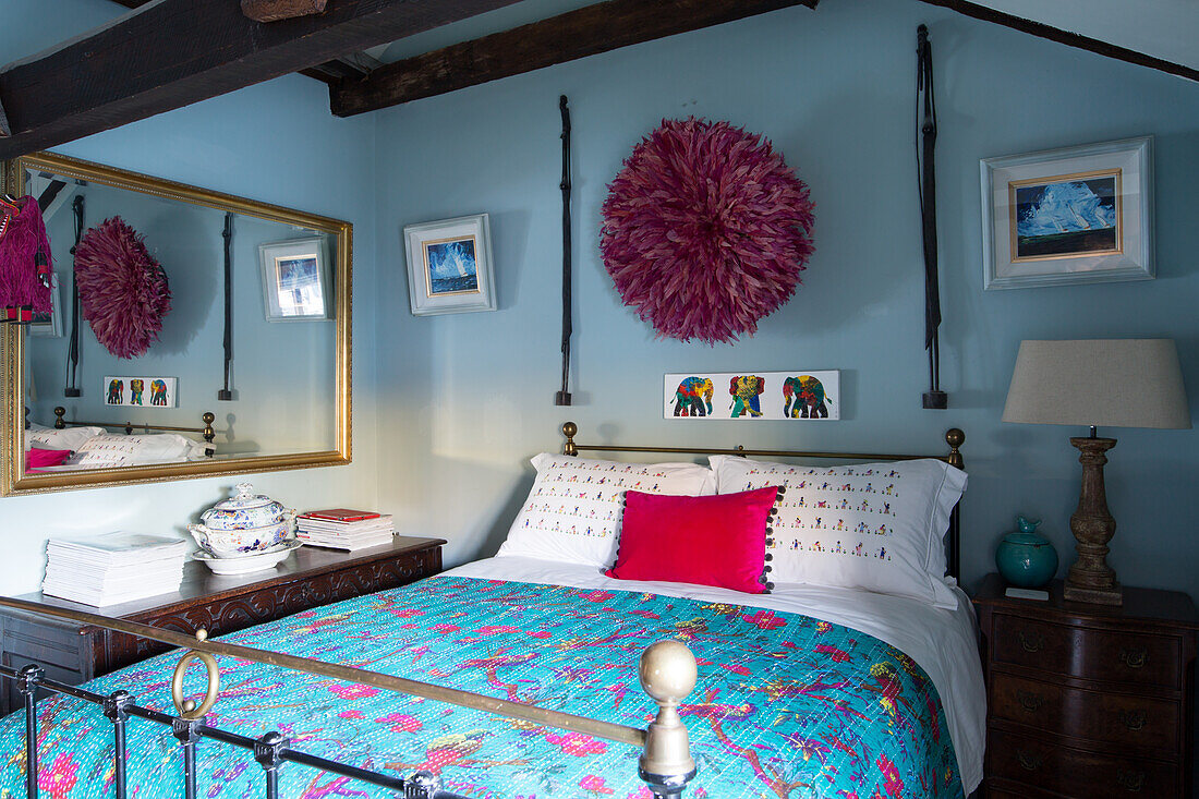 Juju hat on wall above double bed in rustic bedroom