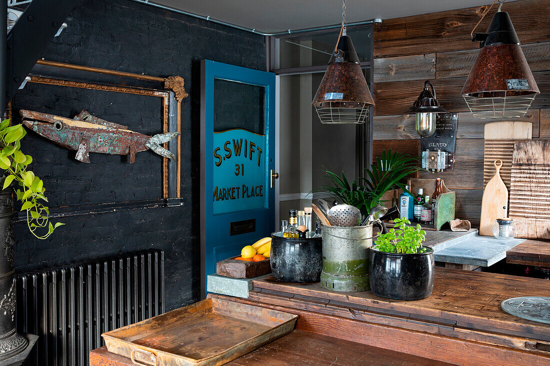 Rustikale Küche mit Bretterwand und Industrieleuchten, Fischmotiv an der Wand