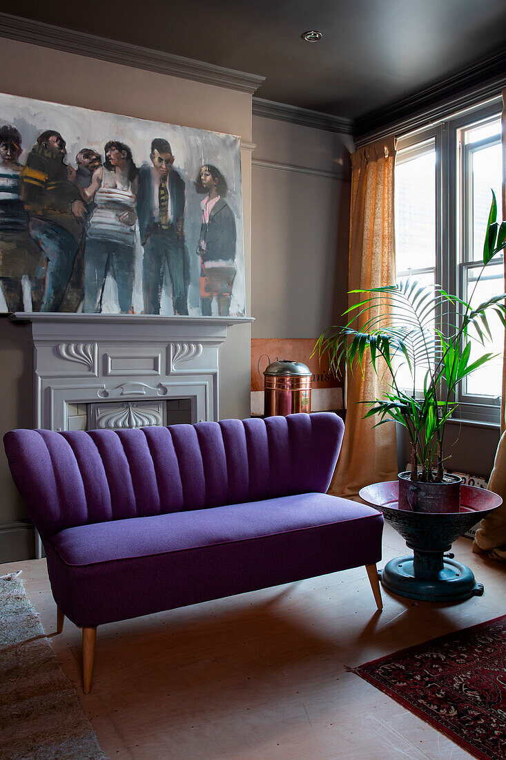 Violettes Sofa und großformatiges Gruppenbild im Wohnzimmer