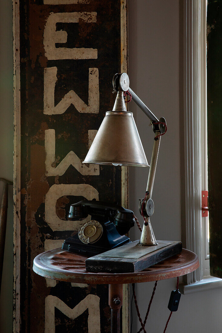 Vintage Schreibtischlampe und Telefon auf rundem Tisch