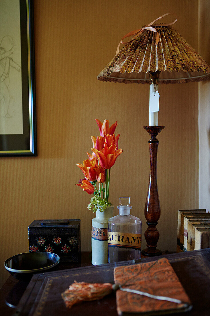 Table lamp and tulips on antique chest of drawers