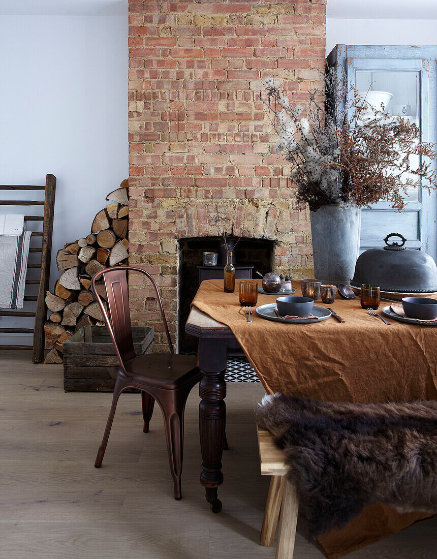 Dining area with rustic wooden table, fireplace and brick chimney