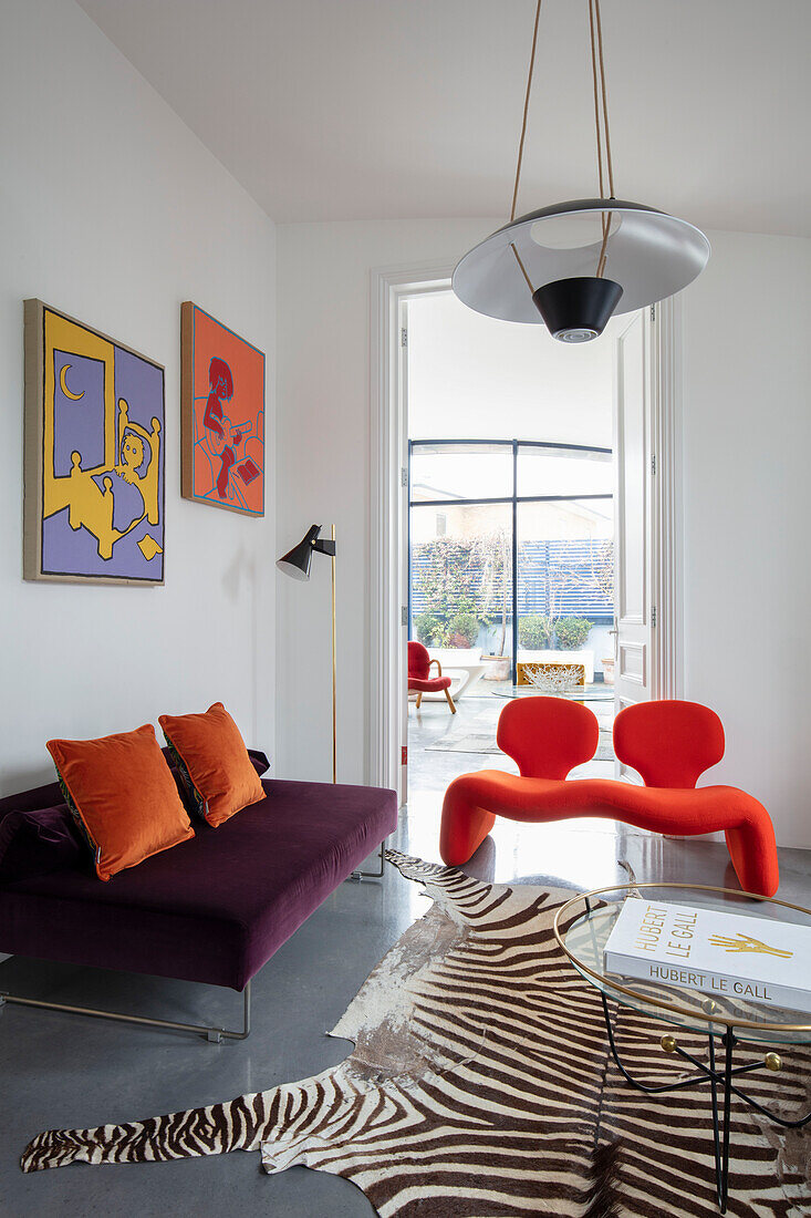 Designer-Sitzmöbel in weißem Wohnzimmer, runder Coffeetable auf Zebrafell