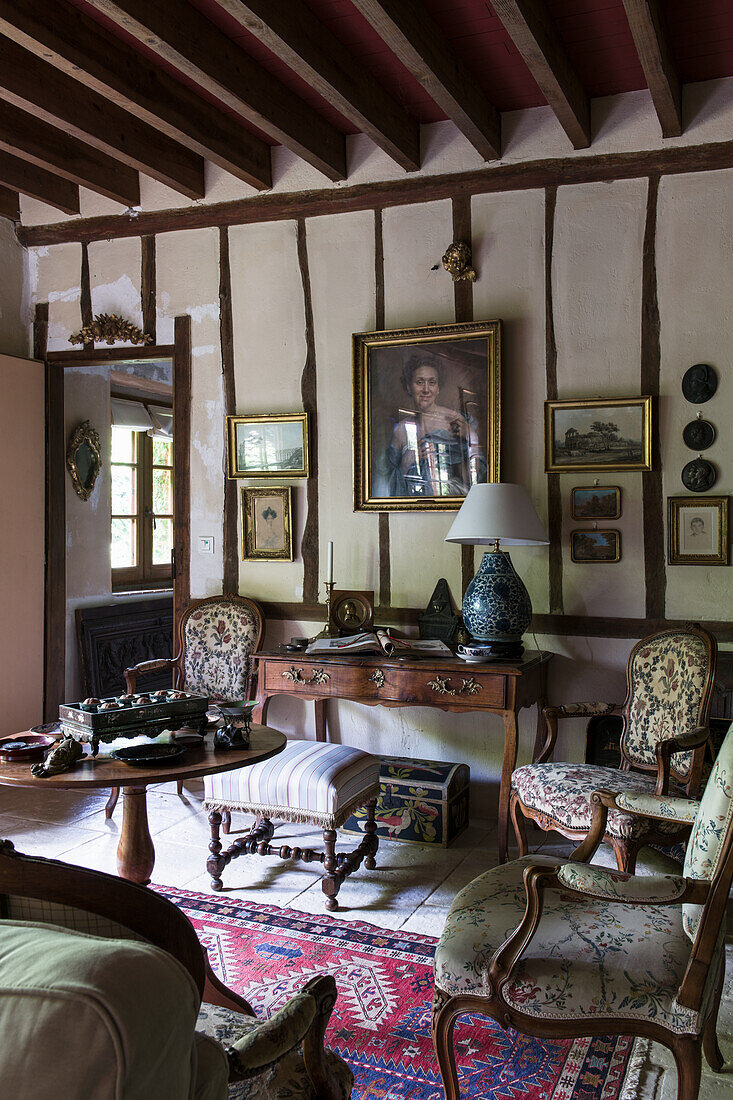 Polstermöbel und antiker Schreibtisch im Salon mit Fachwerkwand
